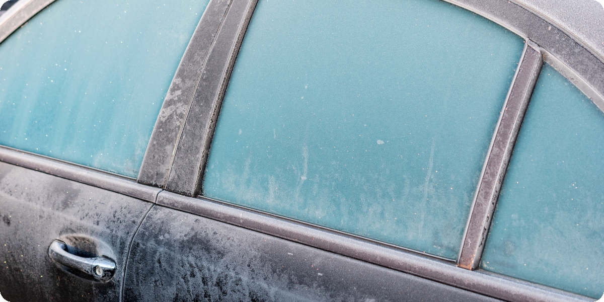 Ein Auto mit vereisten Fenstern und zugefrorener Tür.